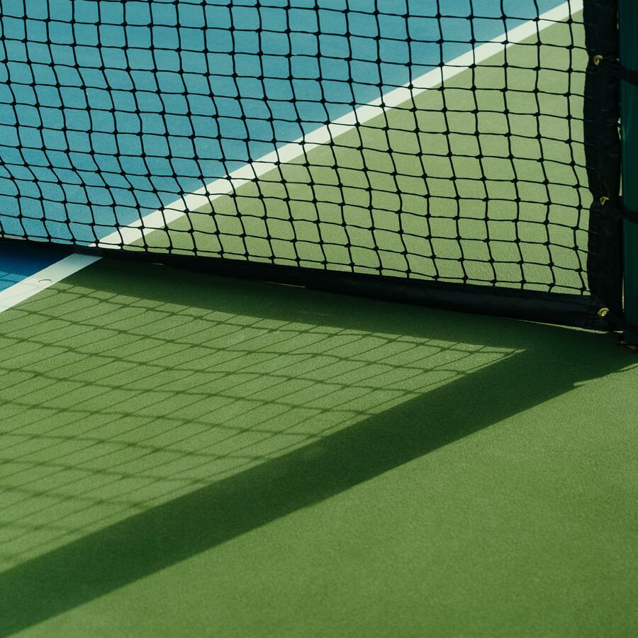 Net reflecting its shadow on the tennis court.